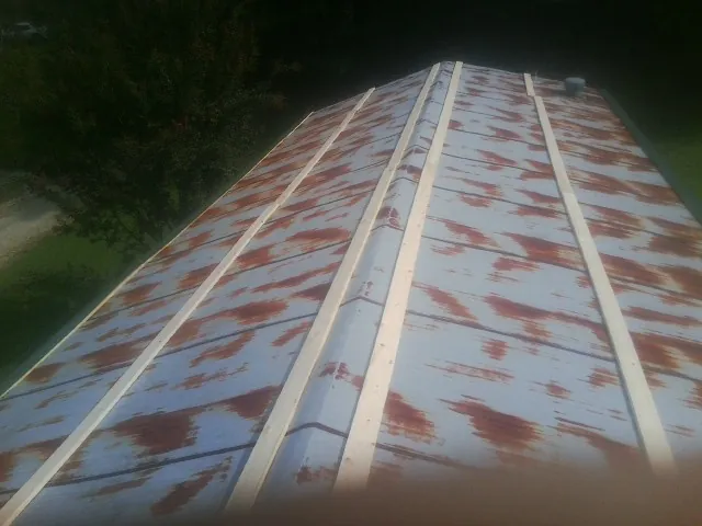 Rusted metal roof panels with new wood purlins before replacement — Storm Damage Roof Repair in Saint James City by Roofing Brothers